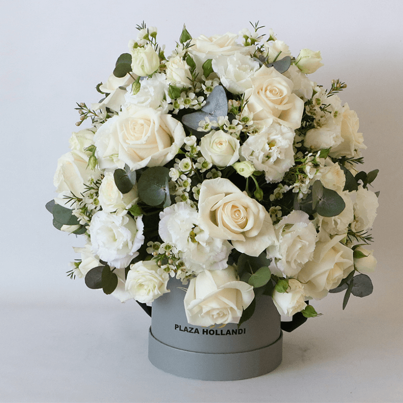 white and green round arrangement in a hat box white roses, eustoma and eucalyptus arranged in a Plaza hollandi hat box