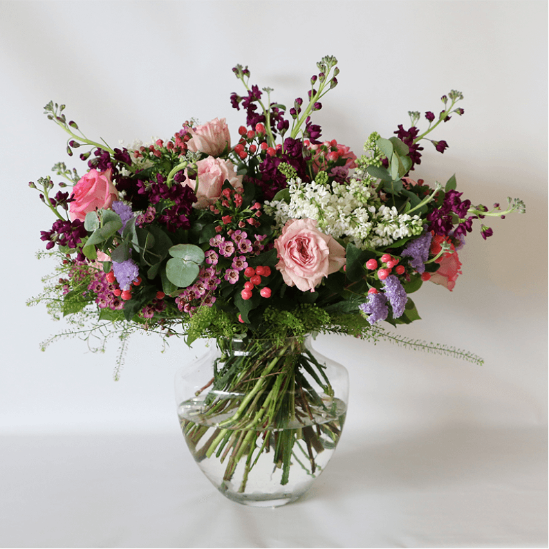 wild meadow flowers in a vase pink, purple white and green flowers arranged in a glass vase