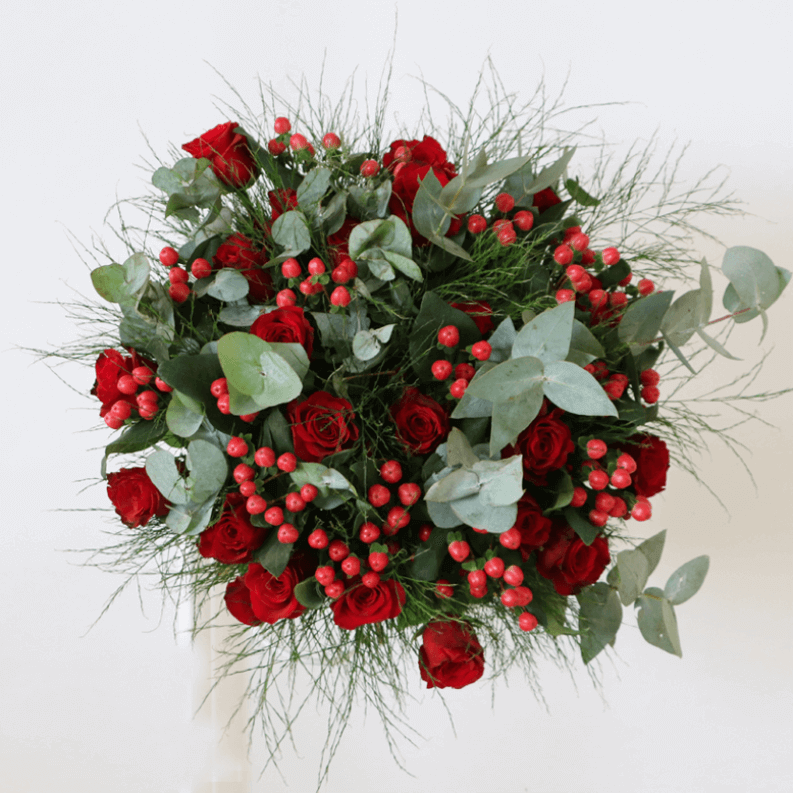 Celia Mae Red rose bouquet with a mix of red roses, hypericum and green leaves.