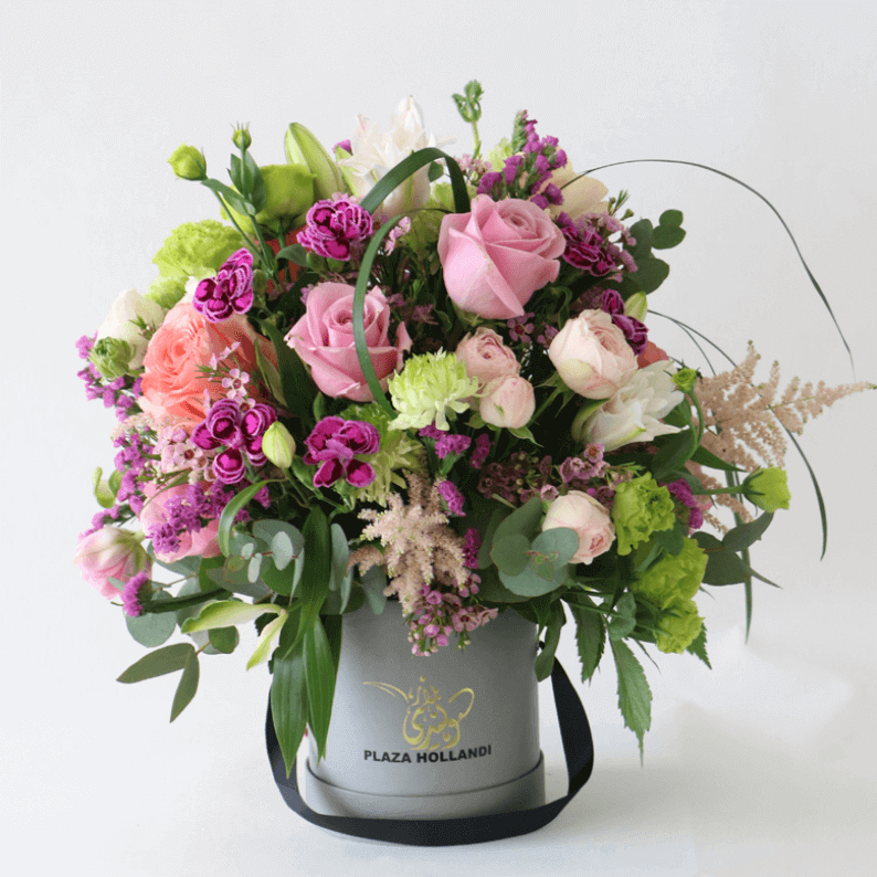 european design arranged in a plaza hollandi box european design of purple roses, ranunculus, astilbe, carnations arranged in a plaza hollandi box