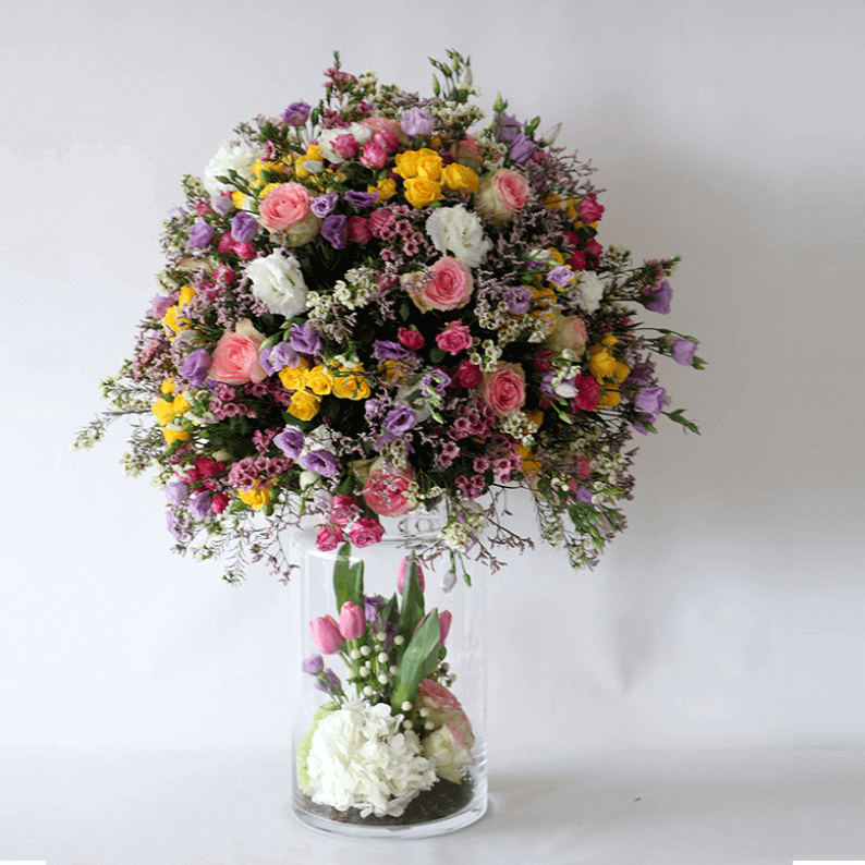 round spring flower design in a vase mixture of spring flowers in a tall vase