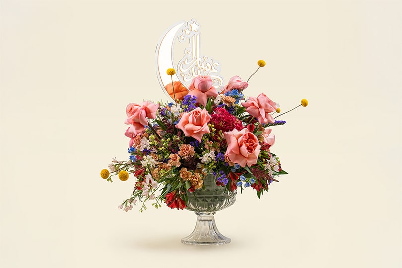 9 Elegant garden mix flower arrangement with roses, astilbe, craspedia, carnations, alstroemeria, and sweet William in glass vase with crescent moon acrylic decoration. 25cm festive floral display.